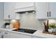 A close-up of the kitchen featuring sleek black cooktop and white cabinets with black hardware at 12051 Lavinia Ln, Charlotte, NC 28277