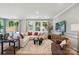 Open living room with hardwood floors, large windows, and comfortable furnishings at 12055 Lavinia Ln, Charlotte, NC 28277