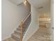 Elegant staircase with a wooden handrail and black iron balusters, complemented by neutral-toned carpet at 1278 Langston Ln, Salisbury, NC 28144
