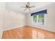 A light bedroom showcases hardwood floors, a ceiling fan, and a window with a view at 13223 Willow Breeze Ln, Huntersville, NC 28078