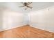 A light bedroom features hardwood floors, a ceiling fan, and a closet at 13223 Willow Breeze Ln, Huntersville, NC 28078