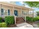 Inviting covered front porch with blue door and matching shutters. Brick stairs add to charm at 13223 Willow Breeze Ln, Huntersville, NC 28078