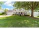 Charming home featuring a well-manicured lawn, inviting porch, and mature shade tree at 13223 Willow Breeze Ln, Huntersville, NC 28078