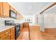 Traditional kitchen with wood cabinets, laminate countertops, and hardwood floors at 13223 Willow Breeze Ln, Huntersville, NC 28078