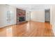 Spacious living room with hardwood floors, brick fireplace, and French door access to sunroom at 13223 Willow Breeze Ln, Huntersville, NC 28078
