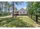 Spacious backyard with lush green lawn, wooden fence and a covered patio for outdoor relaxation at 1406 High Shoals Rd, Lincolnton, NC 28092