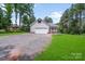 Home with a detached garage, gravel driveway, and a well manicured front yard at 1406 High Shoals Rd, Lincolnton, NC 28092
