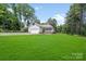 Well-maintained home featuring a detached garage, covered porch, and lush green lawn at 1406 High Shoals Rd, Lincolnton, NC 28092
