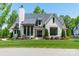 Beautiful exterior featuring a manicured lawn, black-trimmed windows, white board siding and a stylish architectural design at 14228 Ryker Way, Davidson, NC 28036