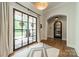 Elegant foyer featuring hardwood floors, a stylish rug, statement lighting, arched doorways and a view of the backyard at 14228 Ryker Way, Davidson, NC 28036