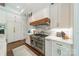 Gourmet kitchen featuring marble backsplash, custom wood hood, and stainless steel range at 14228 Ryker Way, Davidson, NC 28036