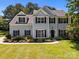 Classic two-story home featuring a symmetrical facade, black shutters, and a tidy front garden at 148 Spring Grove Dr, Mooresville, NC 28117