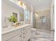 Bright bathroom features a double sink vanity with gold hardware, a glass shower, and marble flooring at 1509 Autumn Banks Way # 4P, High Shoals, NC 28077