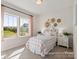 A sunlit bedroom with large windows, a bed with pink and white bedding, and neutral decor at 1509 Autumn Banks Way # 4P, High Shoals, NC 28077