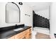 This bathroom features a sleek vanity with a black countertop, a tub, and stylish black and white finishes at 1537 Spangler Dr, Shelby, NC 28150