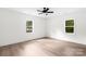Bright bedroom featuring hardwood floors, two windows providing natural light, and a ceiling fan at 1537 Spangler Dr, Shelby, NC 28150