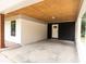 Covered carport showcasing brick and black siding, wood ceiling, a side door, and concrete floor at 1537 Spangler Dr, Shelby, NC 28150