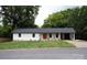 Charming single story home with a red front door, white siding, manicured lawn, and mature trees at 1537 Spangler Dr, Shelby, NC 28150