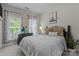 Inviting bedroom featuring an Eiffel Tower poster, plush pillows, and bright windows at 16930 Summers Walk Blvd, Davidson, NC 28036