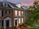Charming brick townhome featuring manicured landscaping, dormer windows and covered front entry at 16930 Summers Walk Blvd, Davidson, NC 28036