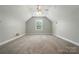 This bedroom features neutral walls and carpet, ceiling fan, and large window for natural light at 170 Heywatchis Dr, Mooresville, NC 28115