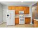 Traditional kitchen featuring wood cabinets, white appliances, and neutral countertops at 170 Heywatchis Dr, Mooresville, NC 28115
