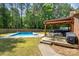 Backyard with inground pool, outdoor seating and grilling area under a wood pergola at 1753 Elmwood Dr, Rock Hill, SC 29730