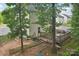 Backyard featuring a wooden deck, partial fence, and mature trees at 1835 Allegheny Dr, Gastonia, NC 28054