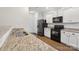 Well-lit kitchen boasts granite countertops, black appliances, and wood-look flooring at 1835 Allegheny Dr, Gastonia, NC 28054