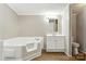 Bright bathroom features a large soaking tub, vanity with storage, and wood-look flooring at 2002 Kingston Rd, Kingstown, NC 28150