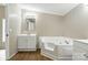 Bright bathroom features a large soaking tub, vanity with storage, and wood-look flooring at 2002 Kingston Rd, Kingstown, NC 28150