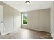Bedroom with wood-look flooring and a window with view of surrounding trees at 2002 Kingston Rd, Kingstown, NC 28150