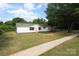 Quaint single-story home featuring white siding, red shutters, and a lengthy concrete driveway at 2002 Kingston Rd, Kingstown, NC 28150