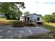 Welcoming one-story home with white siding, red shutters, and a spacious gravel parking area at 2002 Kingston Rd, Kingstown, NC 28150