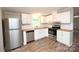 Modern kitchen with stainless steel appliances, white cabinets, butcher block countertops, and vinyl floors at 2002 Kingston Rd, Kingstown, NC 28150