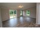 The open living room boasts vinyl flooring, neutral paint, a sliding glass door to the back deck, and large windows at 2002 Kingston Rd, Kingstown, NC 28150