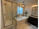 Bright bathroom with a soaking tub, a walk-in shower, and elegant tile work at 2007 Bishops Ct, Cornelius, NC 28031