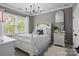 Charming bedroom featuring a white bed frame, stylish chandelier, and natural light at 2007 Bishops Ct, Cornelius, NC 28031