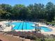 Community pool features a lap lane, lounge chairs, umbrellas, and tables, with surrounding landscaping at 2007 Bishops Ct, Cornelius, NC 28031