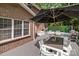 Back deck featuring outdoor dining, lounge chairs and BBQ grill with brick house in background at 2213 Normandin Ct, Charlotte, NC 28216