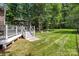 Backyard featuring an outdoor deck, lounge chairs and grass area surrounded by trees at 2213 Normandin Ct, Charlotte, NC 28216