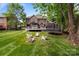 Expansive backyard with a deck, seating area, trampoline and lush green grass at 2213 Normandin Ct, Charlotte, NC 28216