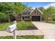Traditional brick home with well-manicured lawn, mature trees, and paved driveway at 2213 Normandin Ct, Charlotte, NC 28216