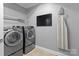 A well-lit laundry room with modern front load washer and dryer, and storage shelves at 2213 Normandin Ct, Charlotte, NC 28216
