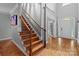 Elegant staircase with wood steps and wrought iron railing leading to the upper level at 2213 Normandin Ct, Charlotte, NC 28216
