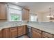 A well-lit kitchen with stainless steel sink, stone countertops, and wooden cabinets at 244 River Clay Rd, Fort Mill, SC 29708