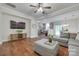 Inviting living room with hardwood floors, a large television, an open floorplan, and a ceiling fan at 244 River Clay Rd, Fort Mill, SC 29708