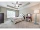A relaxing main bedroom offers neutral colors, large window, and a ceiling fan at 244 River Clay Rd, Fort Mill, SC 29708