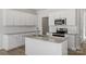 Bright kitchen boasts white cabinets, granite countertops, stainless appliances, and island with sink at 2712 Lehigh Rd, Charlotte, NC 28208