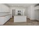 Bright kitchen boasts white cabinets, granite countertops, stainless appliances, and island with sink at 2712 Lehigh Rd, Charlotte, NC 28208